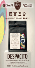 A coffee bag product display on a pedestal with branding for FiveO and SCAs 85, featuring the Despacito Colombia/Brazilia/Costa Rica coffee beans.