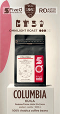 A coffee bag displayed on a pedestal with promotional text and branding. The product shown is a black coffee bag labeled Columbia Huiila, Five O, with a red and white side panel.