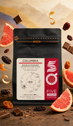 Pungă de cafea de specialitate Five Origins Columbia Excelso Paramo, înconjurată de grapefruit, ciocolată cu lapte și fructe uscate, pe fundal premium inspirat de Columbia.